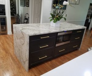 Waterfall white and gray marble island with dark brown cabinets