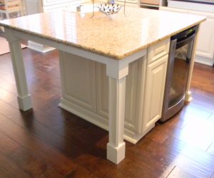 Kitchen island with white cabinets and two white custom columns